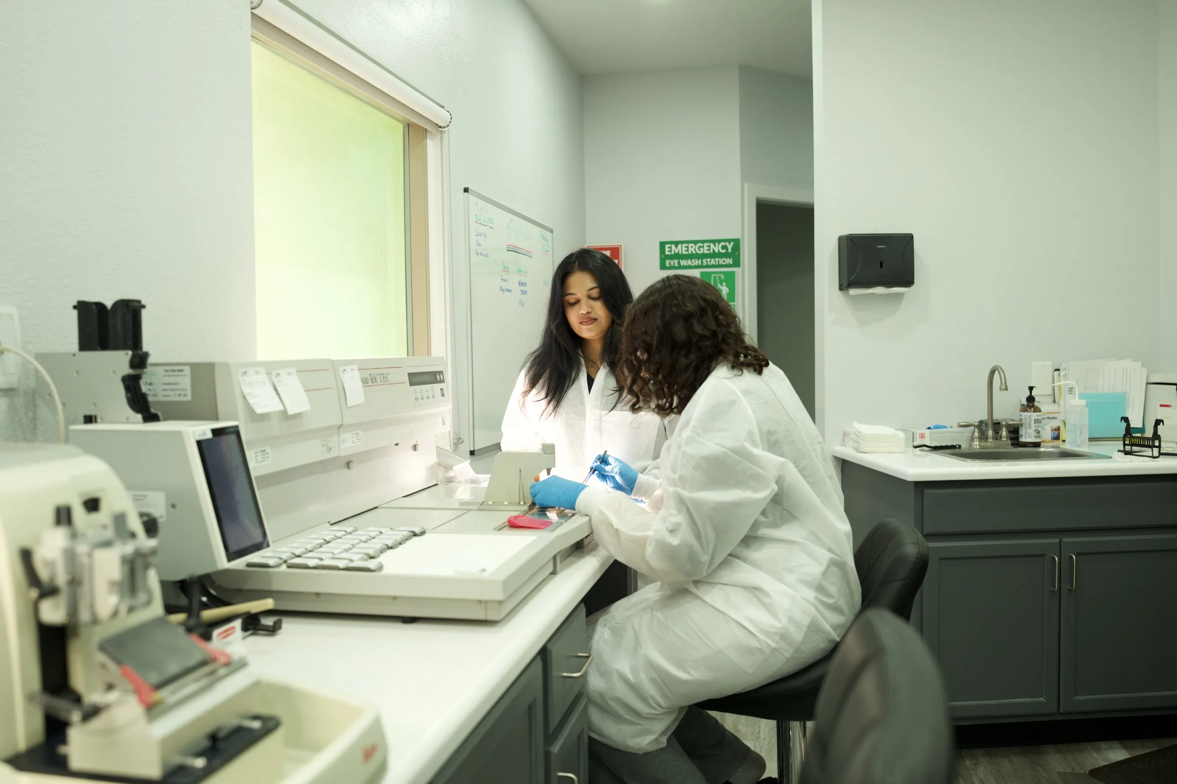 Lab technicians in white coats working at diagnostic analyzer